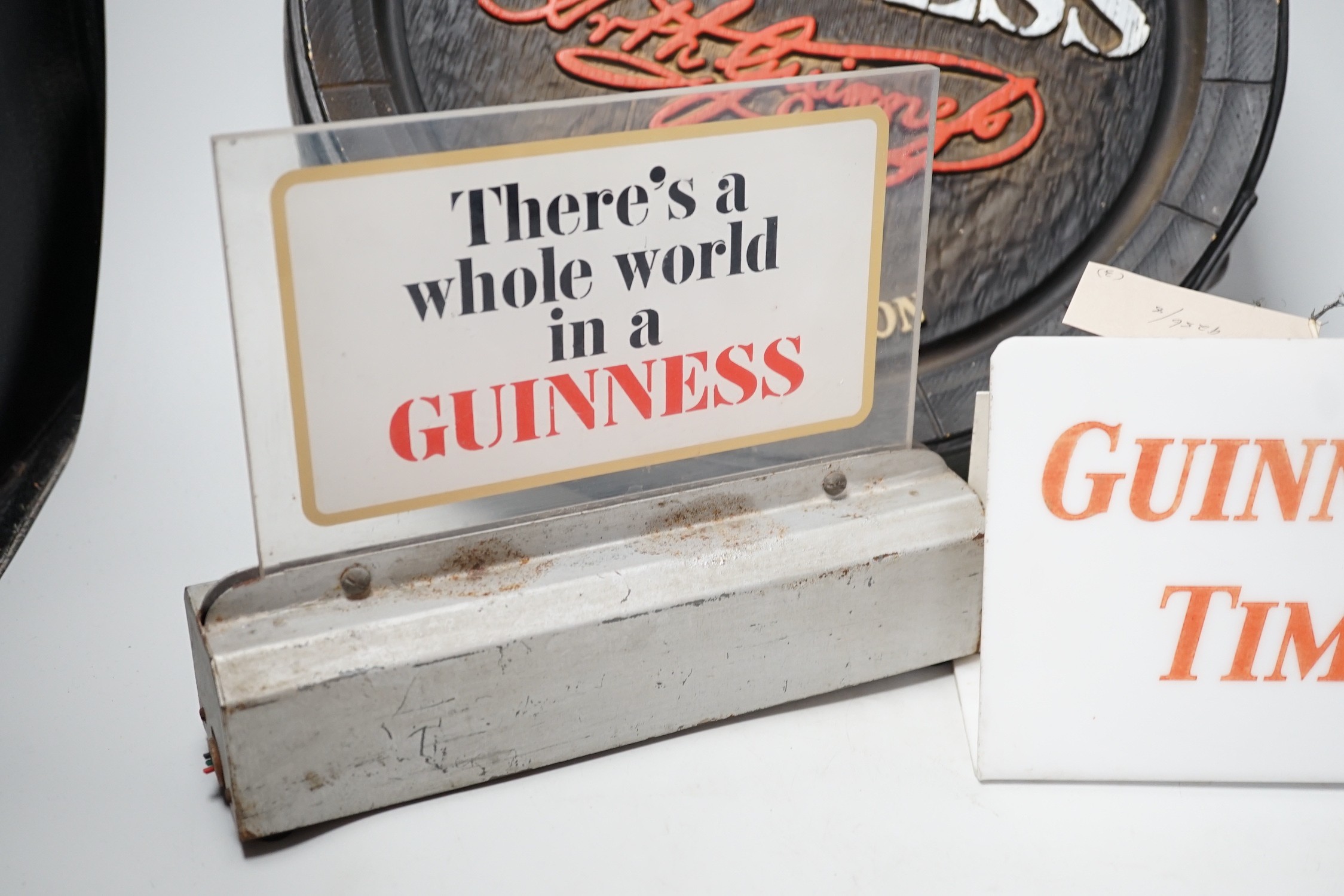 A Guinness time illuminating timepiece, Guinness display light and a Guinness advertising barrel cover